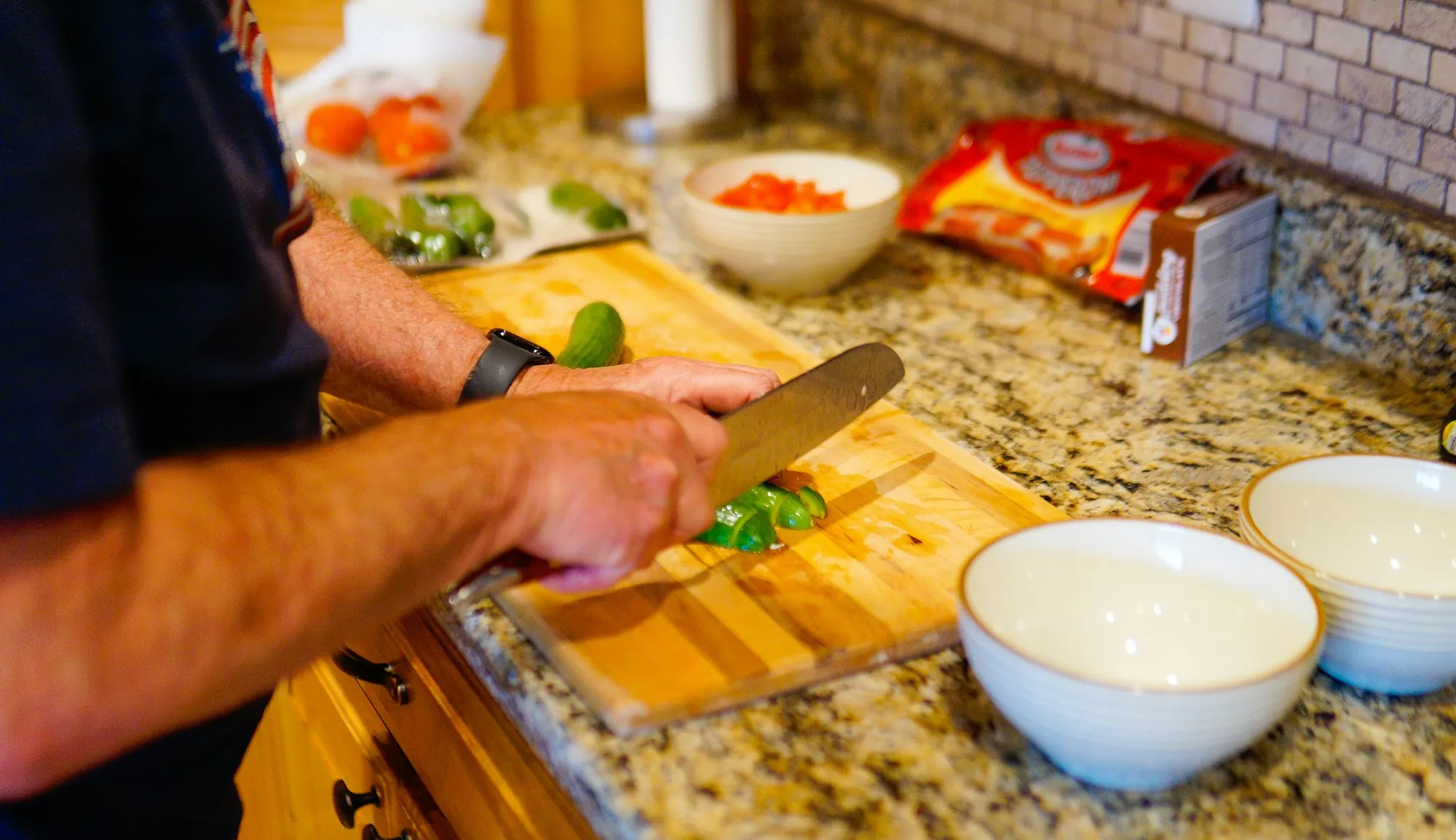 Green vegetables being chopped on a wooden board