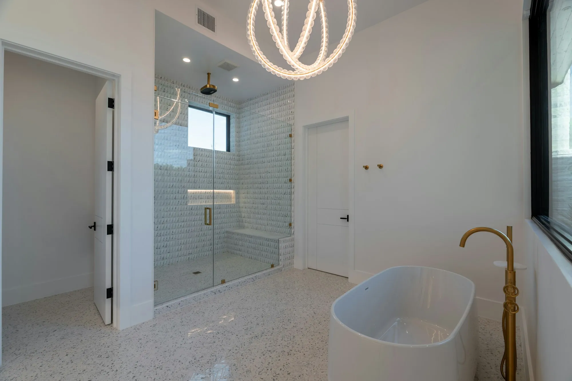 A white bathroom with a bath and a glass shower