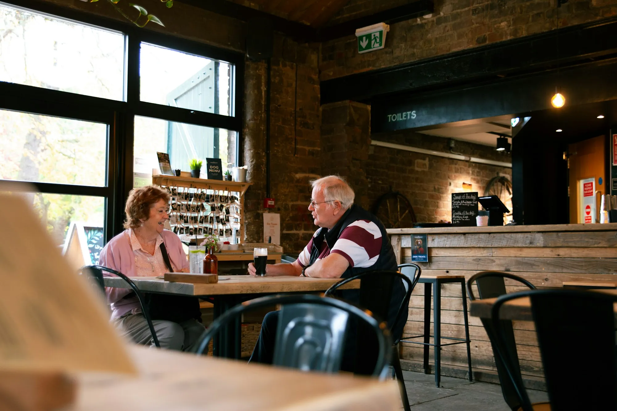 An older couple talking at a cafe table
