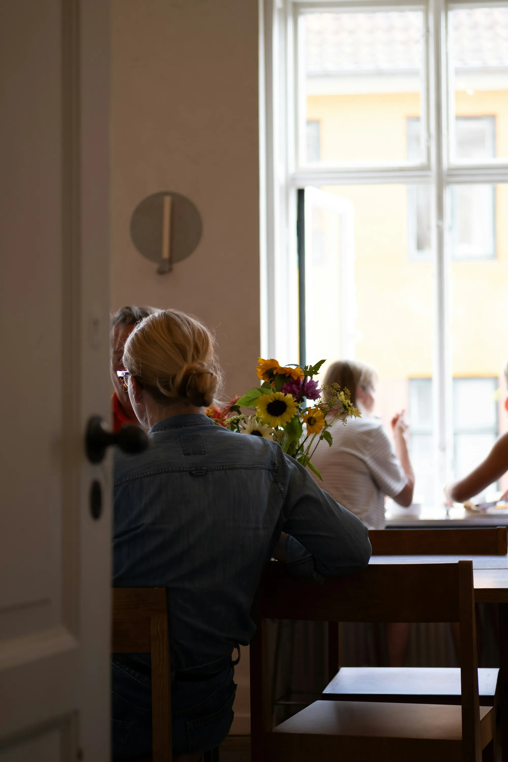 People sitting and talking round a wooden table